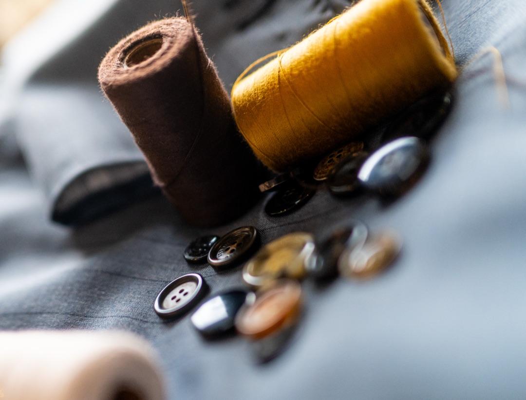 Thread spools and buttons on suiting cloth